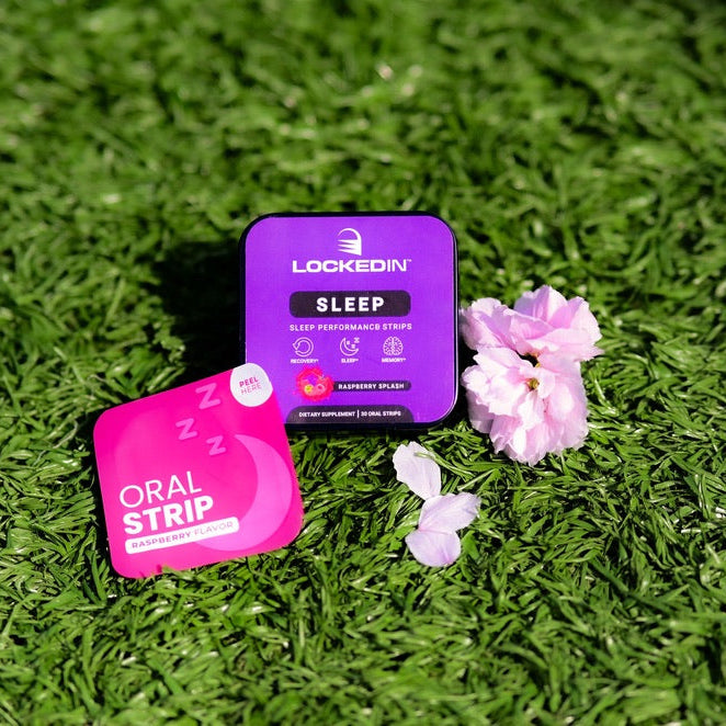Two small containers labeled 'Oral Strip' and 'Sleep' on grass with flowers.