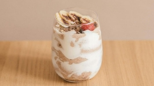 chocolate-banana recovery smoothie in a glass sitting on wooden table