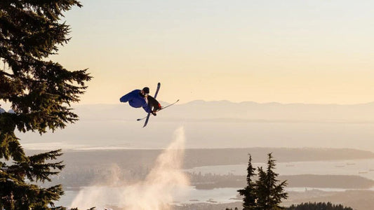 Kei hitting a ski jump doing a flip with a heel grab while in the air