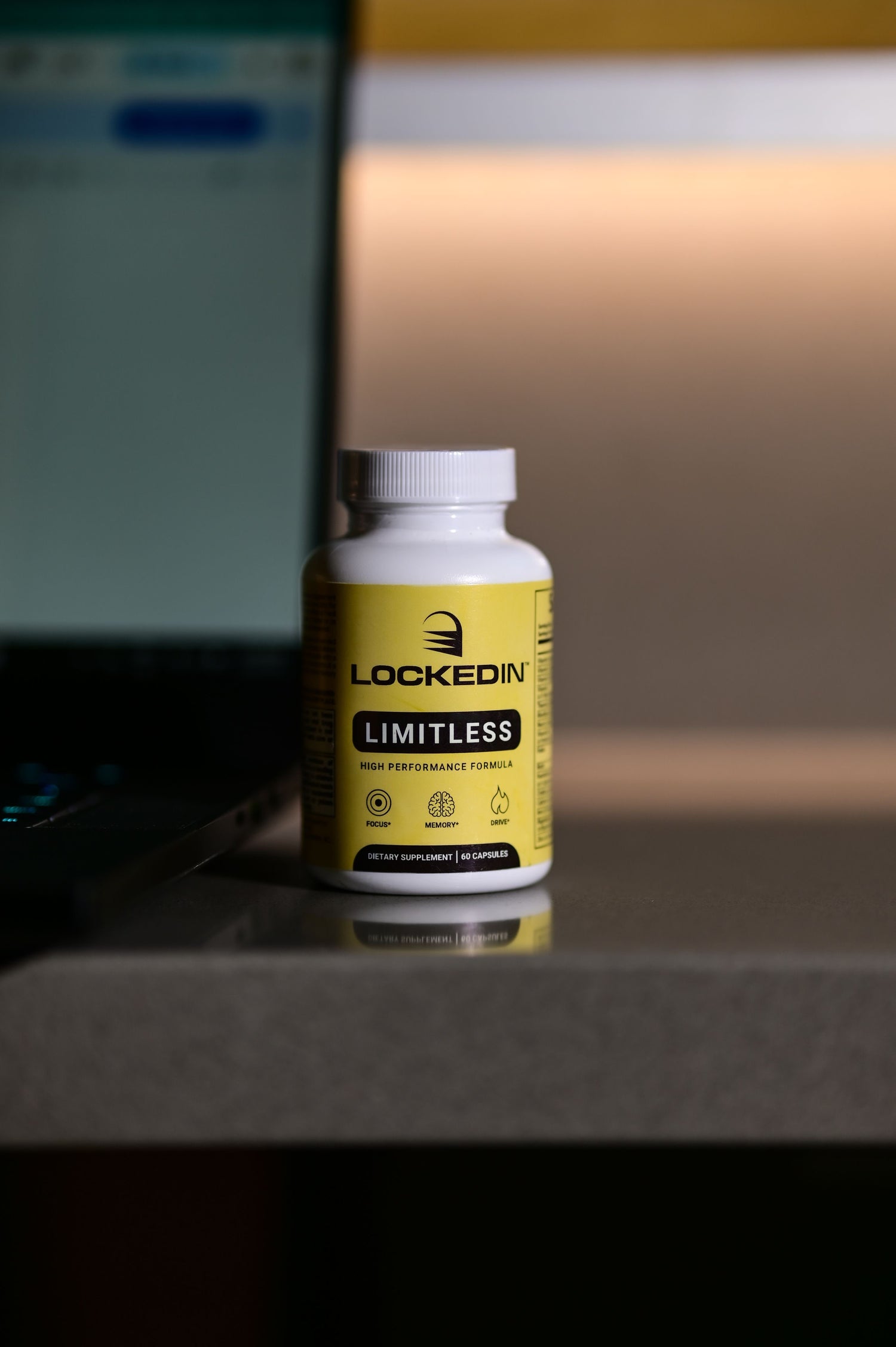Yellow supplement bottle labeled 'Lockedin Limitless' on a surface with a blurred background