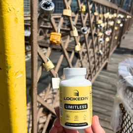 Hand holding a 'Lockedin Limitless' supplement bottle with a bridge background