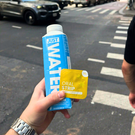 locked in party hangover supplement holding in hand with water